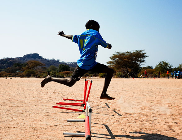 Deporte y educación en Malawi con un niño saltando vallas